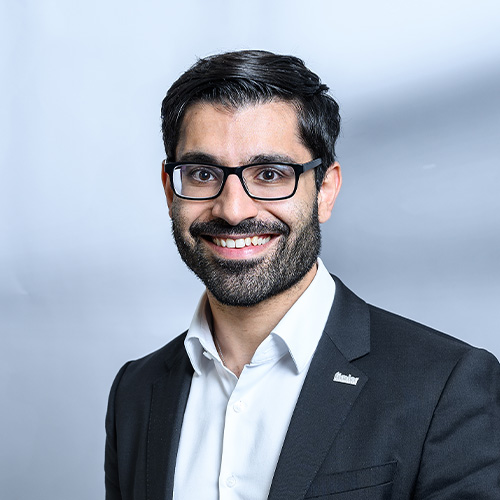 Porträt von Cemal Acikbas vor neutralem Hintergrund, frontal aufgenommen.