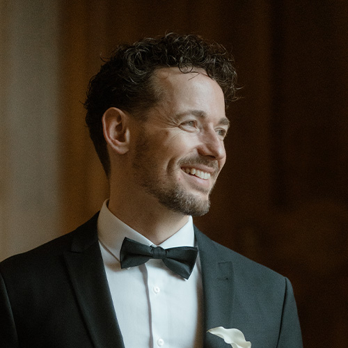 Porträt von Florian Brucker vor neutralem Hintergrund, frontal aufgenommen.