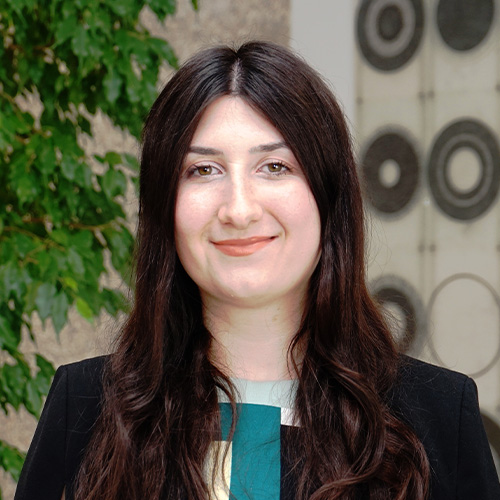 Porträt von Lavinia Enache vor neutralem Hintergrund, frontal aufgenommen.