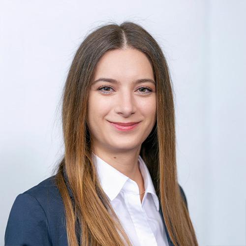 Porträt von Maria Kadan vor neutralem Hintergrund, frontal aufgenommen.