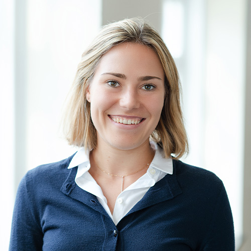 Porträt von Marlene Peck vor neutralem Hintergrund, frontal aufgenommen.