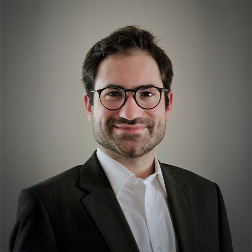 Porträt von Matthias Widman vor neutralem Hintergrund, frontal aufgenommen.