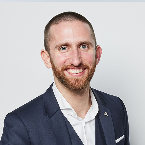 Porträt von Philip Plank vor neutralem Hintergrund, frontal aufgenommen.