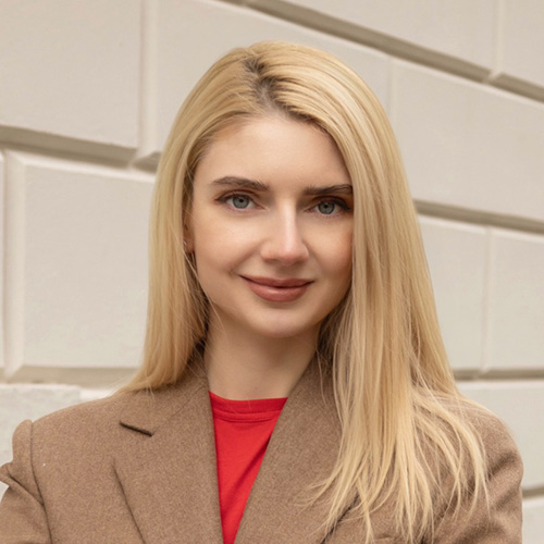 Porträt von Tetyana Kohansal vor neutralem Hintergrund, frontal aufgenommen.